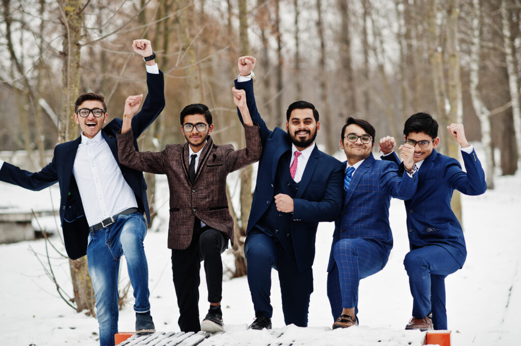 Group of happy students celebrating their successful credit transfer in Ernakulam, smiling and posing together outdoors with scenic greenery in the background.